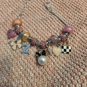 pink and black charm bracelet with heart and bow charms